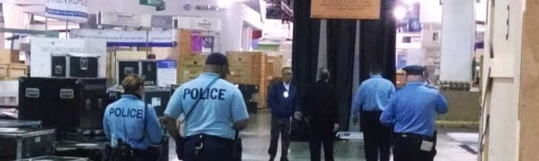 Authorities ID and escort unauthorized workers off show floor at Pennsylvania Convention Center.
