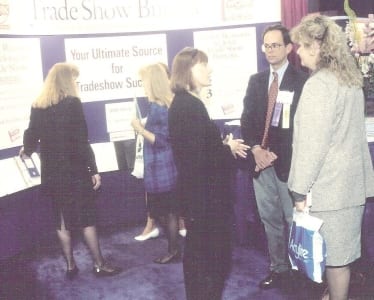 E. Jane Lorimer conversing at TSB booth during a past EXHIBITOR Show
