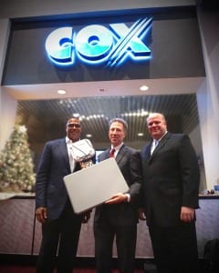 Cox President Pat Esser (center) displays one of 2,000 access points deployed by Cox Business throughout LVCC. Esser is joined by Cox Business SVP Steve Rowley (right) and Cox Business/Hospitality Network Vice President Derrick Hill.