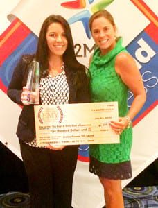 EMY Winner Jessica Gauvin (left) is presented with her check and trophy from The Expo Group's Creative Director Nicole O'Leary