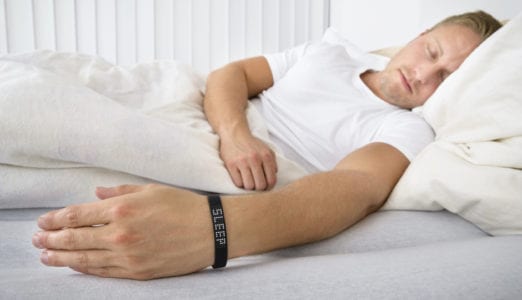 Portrait Of A Man Sleeping On Bed Wearing Smart Wristband