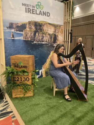 Harpist performing at the Meet in Ireland booth during IMEX America 2024 in Las Vegas