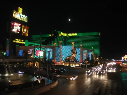 MGM Grand Las Vegas at night with bright neon lights and traffic on the Strip.