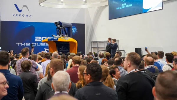 Crowd gathered around the Vekoma booth at IAAPA Expo 2025 during a press announcement unveiling new ride technology.