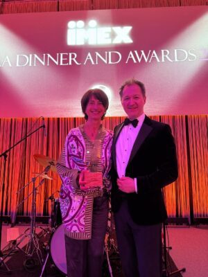 Anne-Marie Baezner holds the 2026 JMIC Unity Award at the IMEX Gala Dinner and Awards.