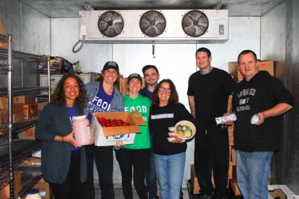 Food Recovery Network volunteers and partners hold recovered food inside a cold storage area.