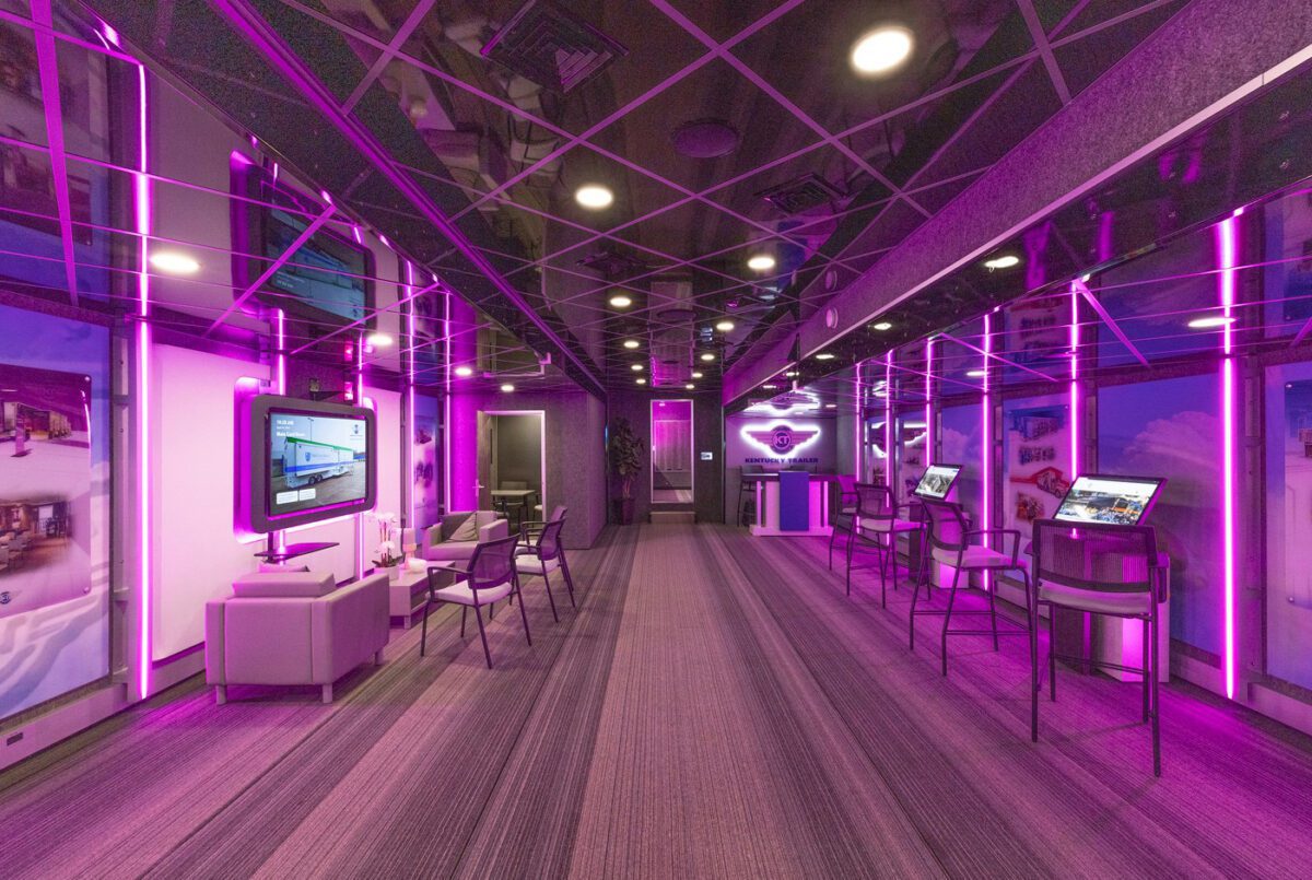 Interior of a Kentucky Trailer Specialty Vehicles mobile marketing trailer with seating, displays, and purple lighting.