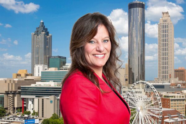 Cindy Moss stands in front of the Atlanta skyline.