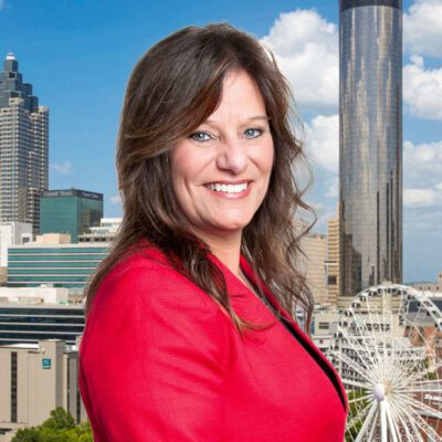 Cindy Moss stands in front of the Atlanta skyline.