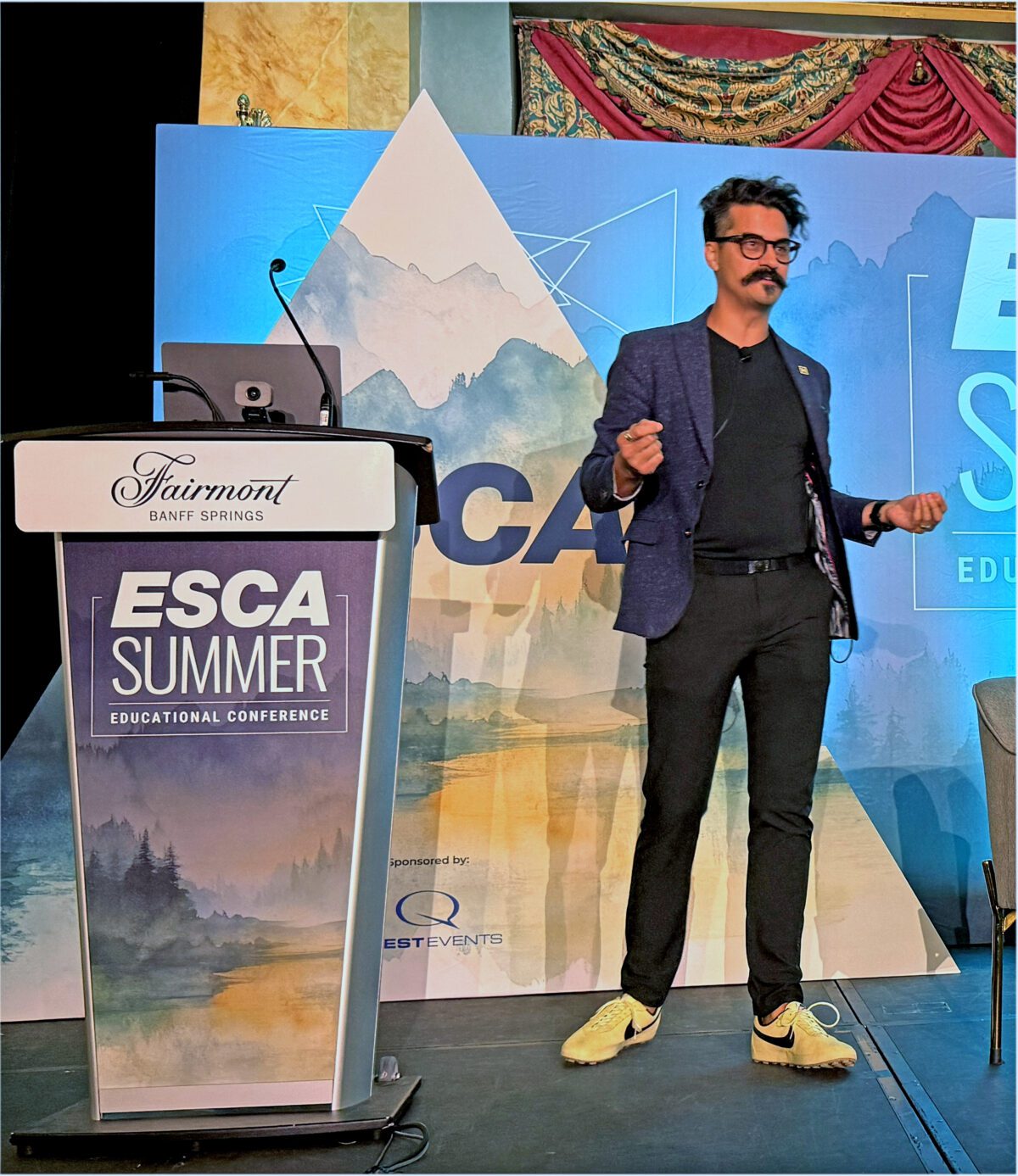 Marc Ghafoori speaks onstage during the ESCA Summer Educational Conference in Banff.