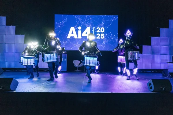 Illuminated drummers perform onstage during Ai4 in Las Vegas