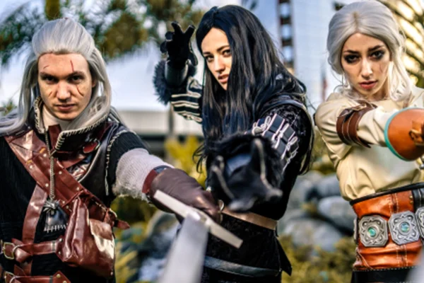 Three cosplayers pose with prop weapons outside Comic-Con in San Diego