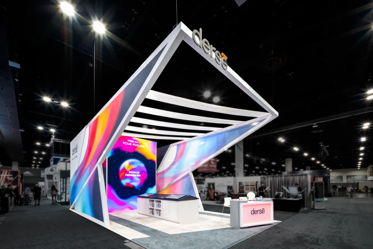 Derse medium island exhibit with angular architecture, illuminated graphics, and digital displays